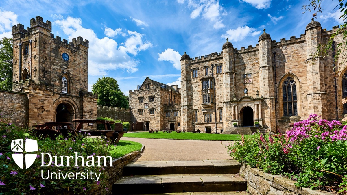 The courtyard of Durham Castle, with lawn, flowerbeds and the castle keep